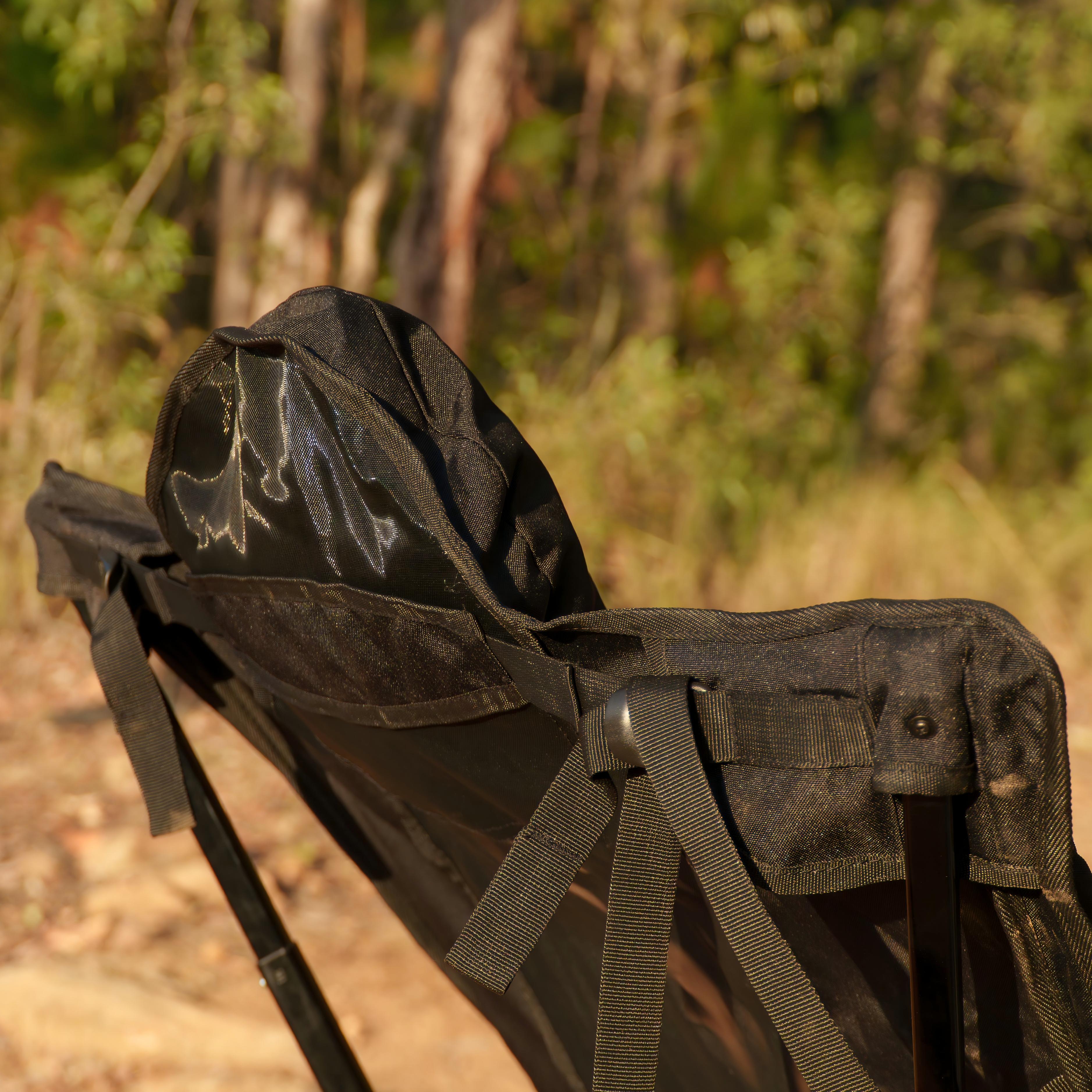 OPENROAD ergonomic camping chair rear close-up showing adjustable padded headrest and strap system in a bushland campsite.
