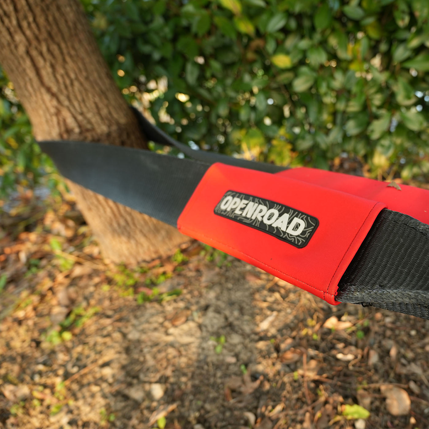 Heavy-duty tree saver strap securely wrapped around a tree trunk for off-road recovery