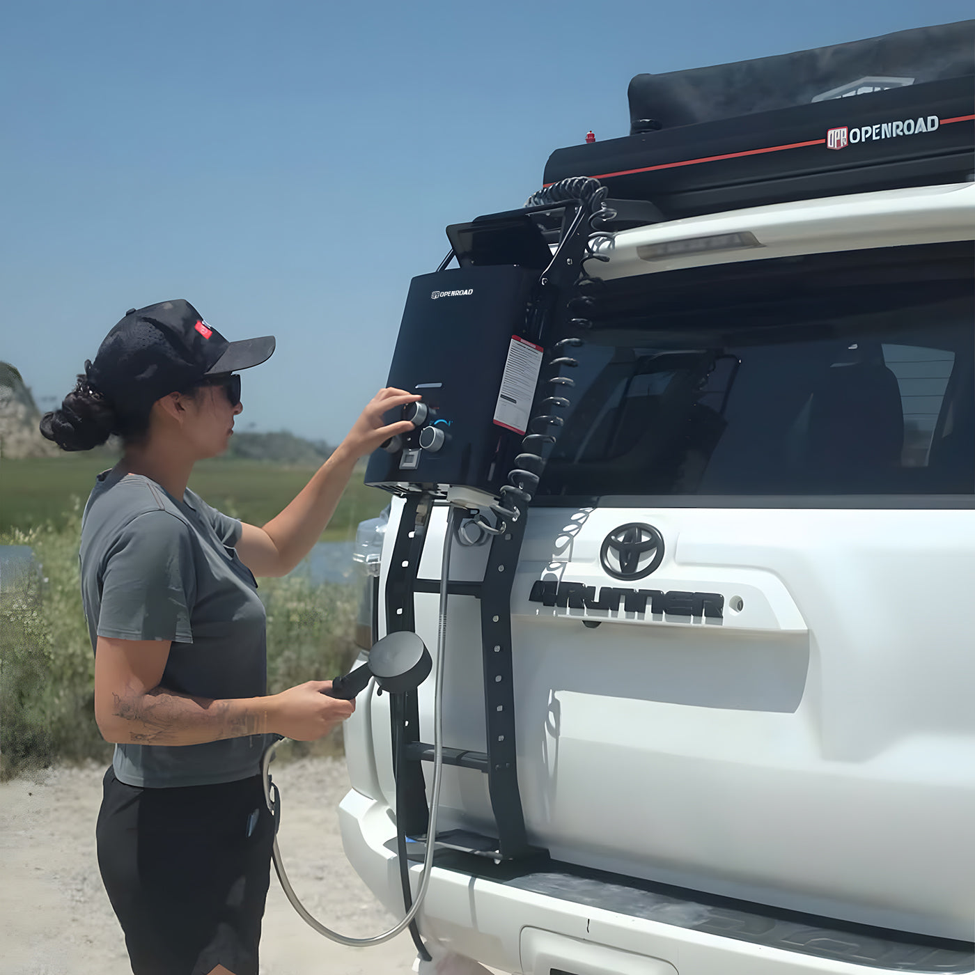 Using OpenRoad portable camping hot water system mounted on a 4WD ladder for outdoor shower setup