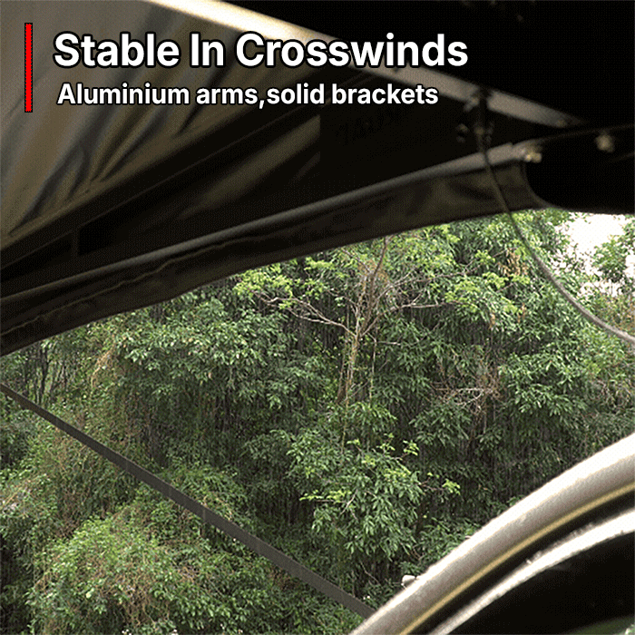 OPENROAD 180° awning in heavy rain; aluminium support arms, solid brackets and tie-down strap keep the canopy stable with clean runoff