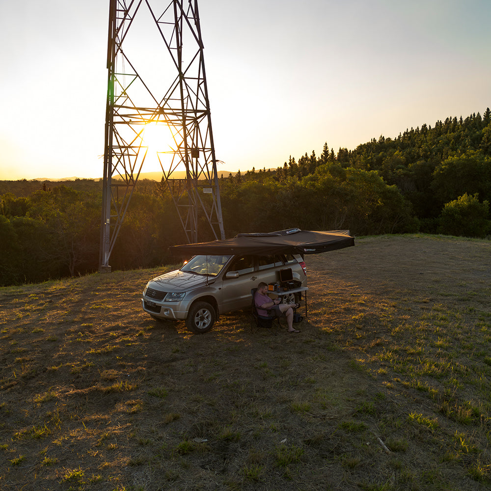 Openroad 180-degree roof-rack awning deployed beside a 4WD, lightweight side canopy for camp use