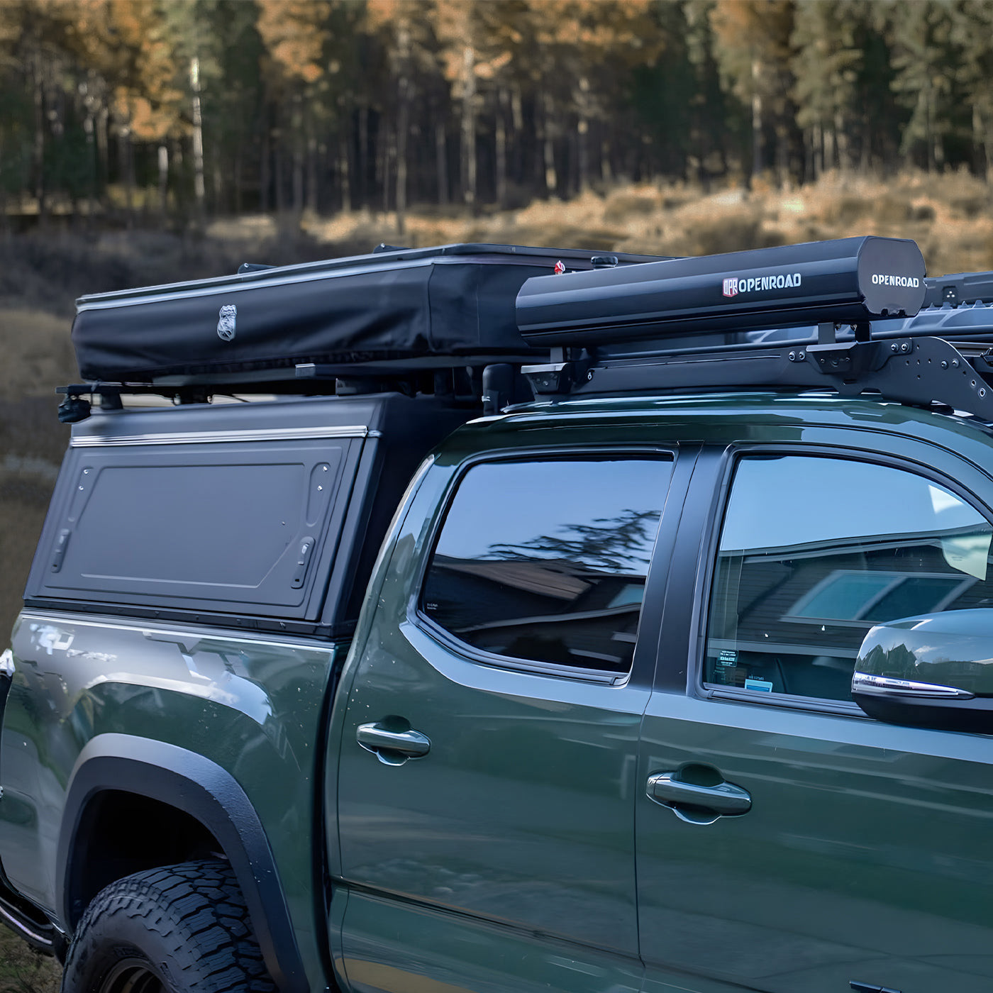 OPENROAD 4WD water tank mounted on a dual-cab ute roof rack, black hard case beside a rooftop tent and canopy