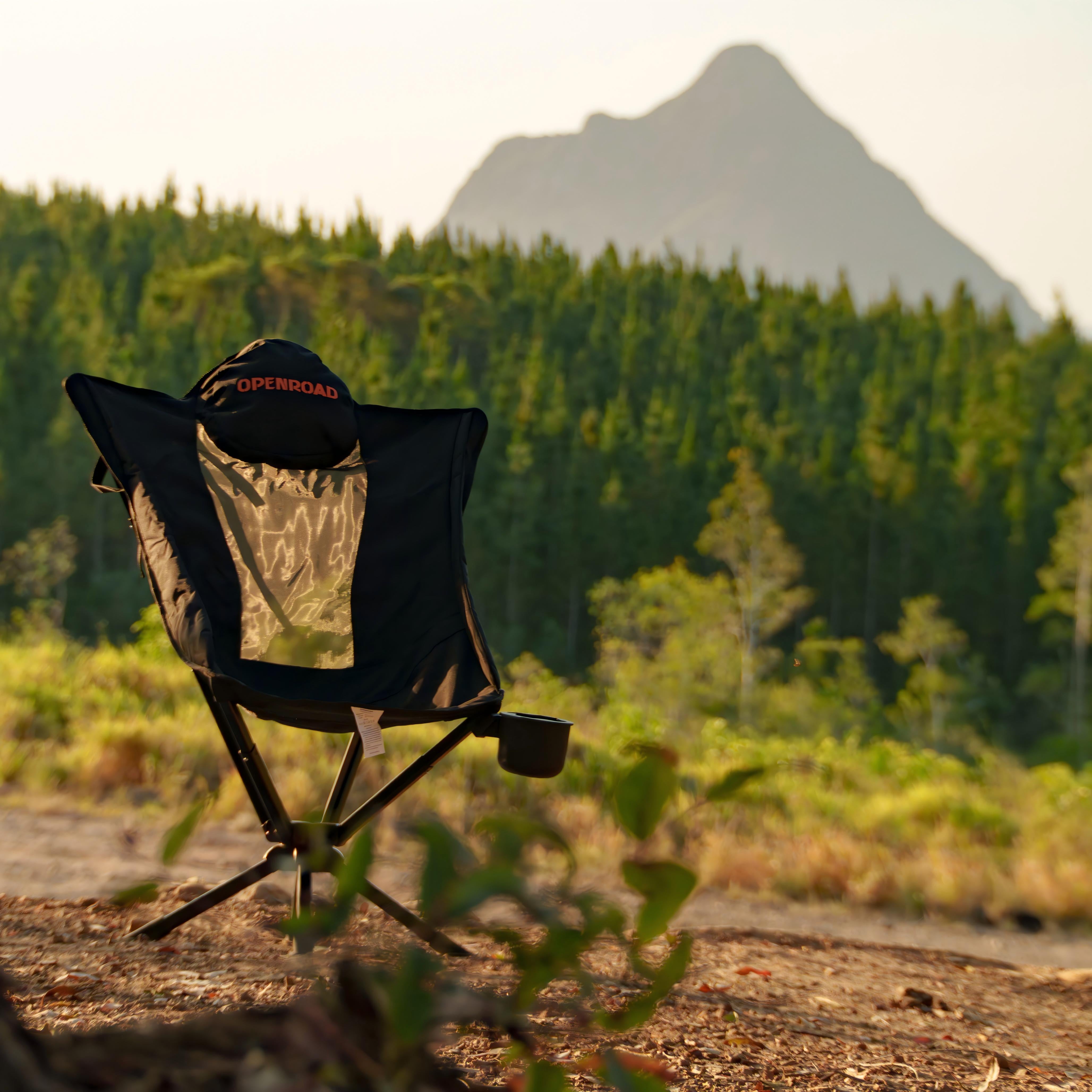 OPENROAD ergonomic camping chair with mesh back at a bush campsite, mountain backdrop at sunset; best camping chair for relaxed support