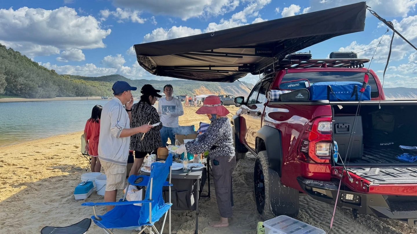 Toyota Hilux set up with OPENROAD 270 awning on a beach campsite, providing wide shade coverage for family camping