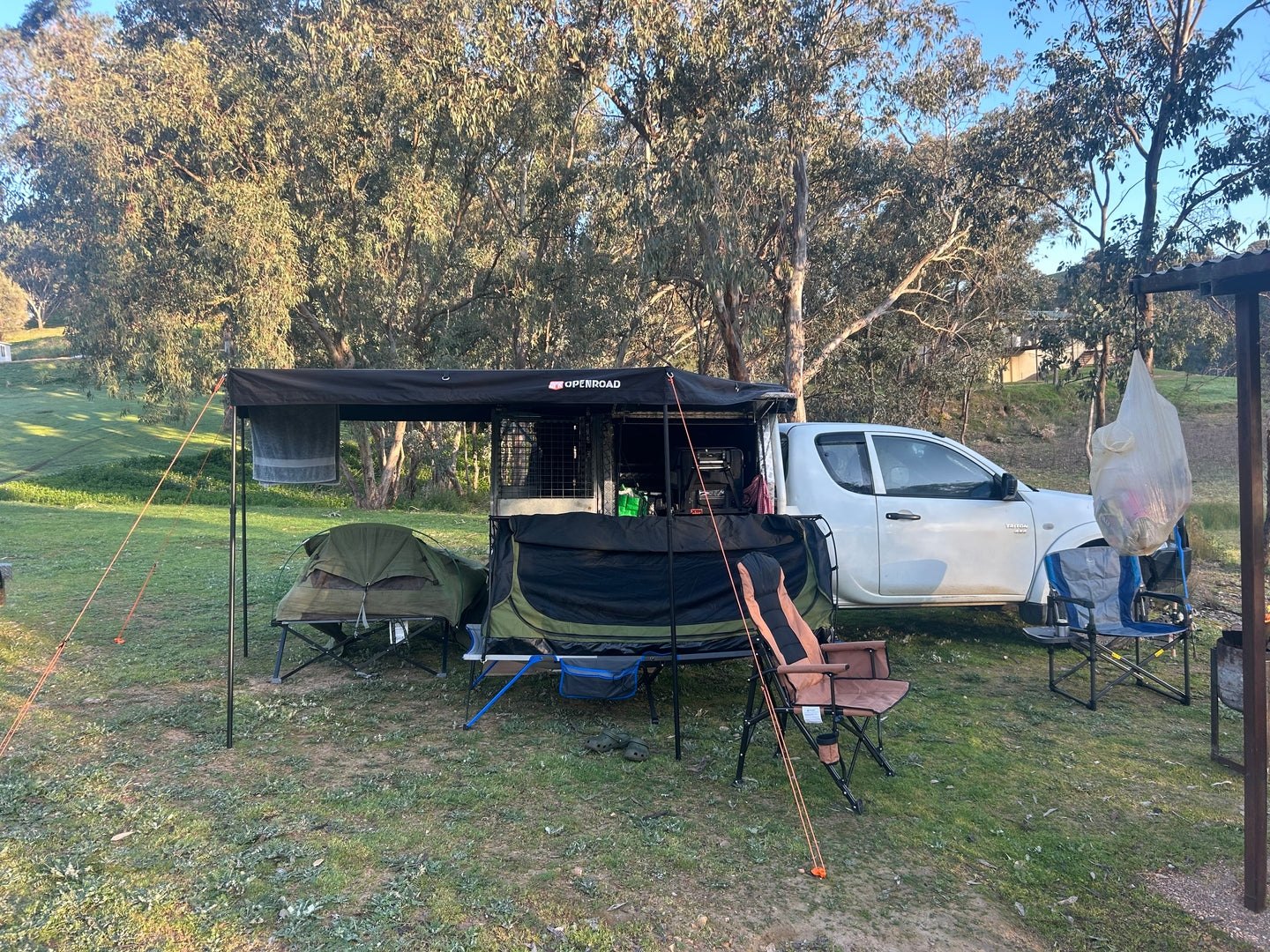 Ute camping setup with side awning providing shade beside the vehicle and traile